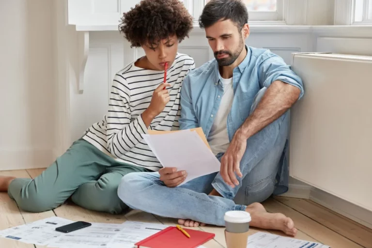 homem e mulher olhando para papeis financeiros analisando empréstimo consignado